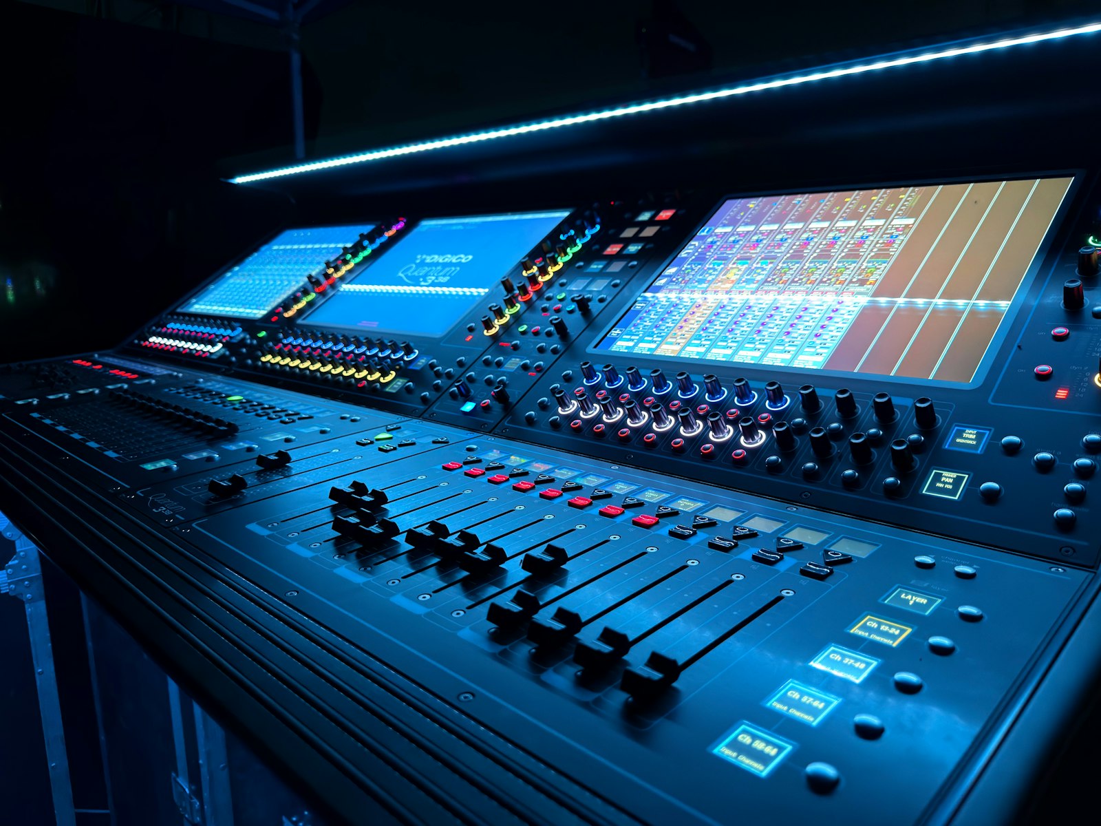 Professional audio mixing console illuminated in blue