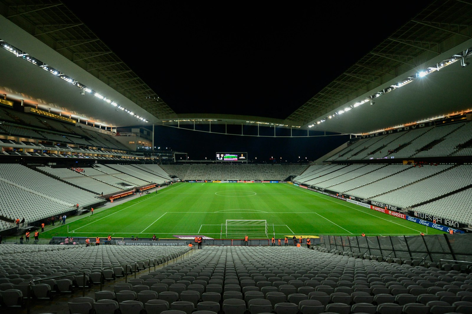 Floodlit football pitch surrounded by stadium seating